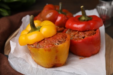 Photo of Delicious stuffed bell peppers served on wooden table, closeup