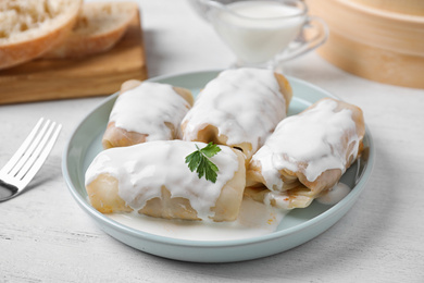 Photo of Delicious cabbage rolls served on white wooden table