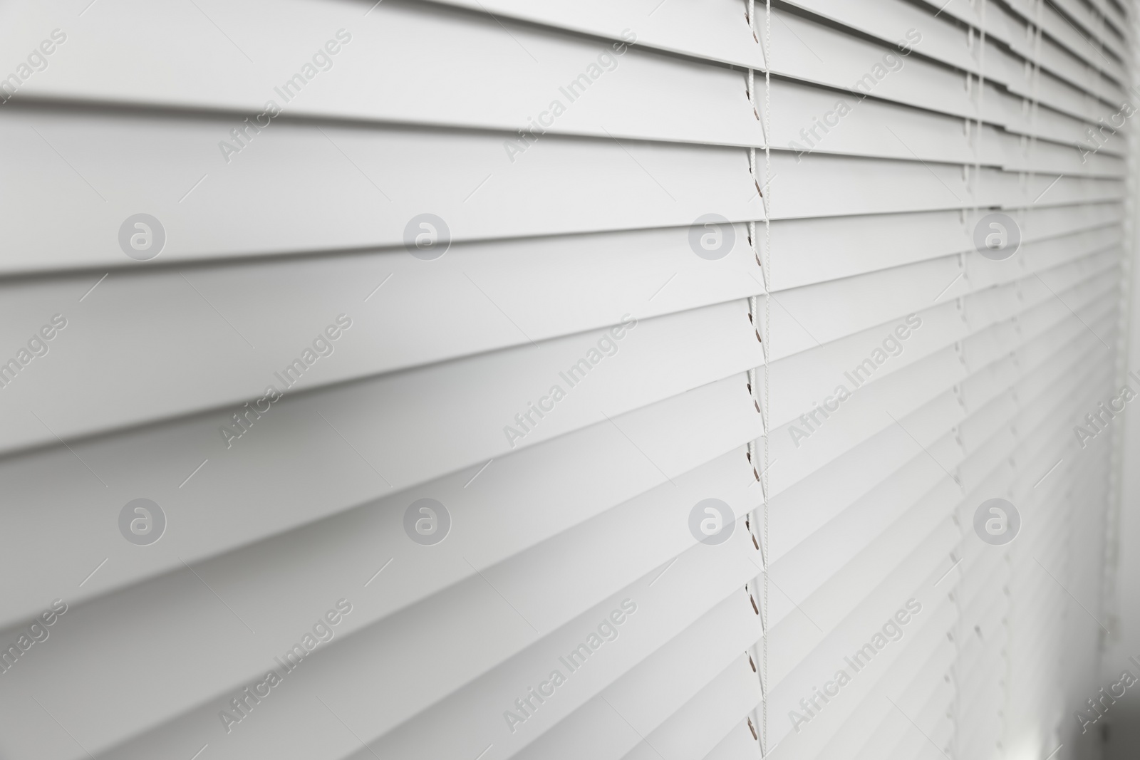 Photo of Closeup view of horizontal blinds on window indoors