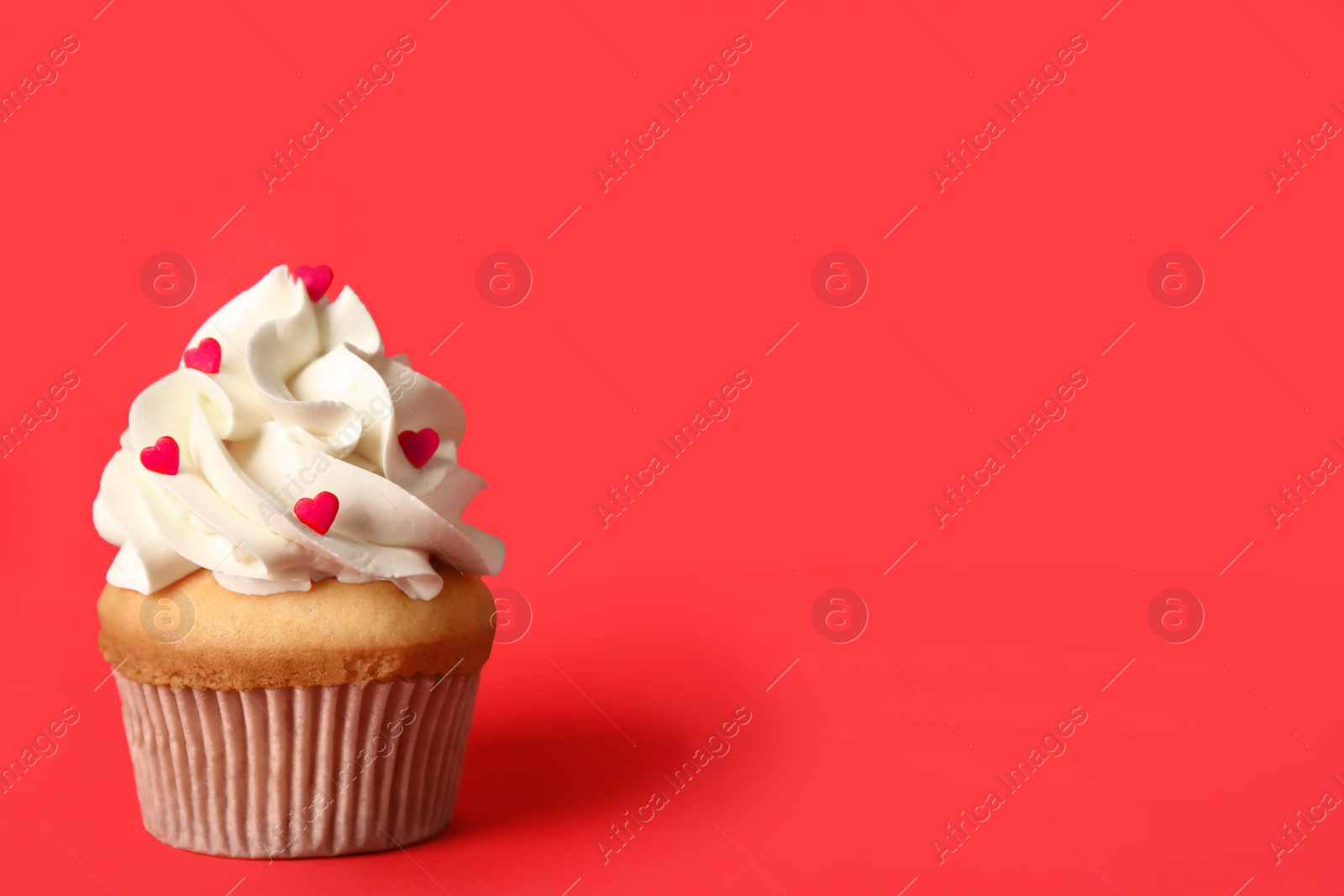Photo of Tasty cupcake on red background, space for text. Valentine's Day celebration