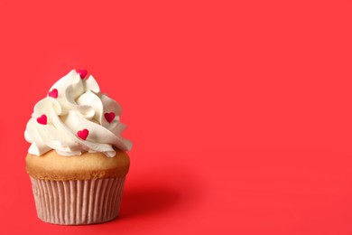 Tasty cupcake on red background, space for text. Valentine's Day celebration