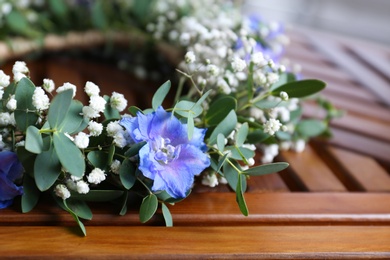 Photo of Beautiful flower wreath on wooden background, closeup