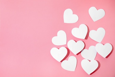 Small paper hearts on color background, top view