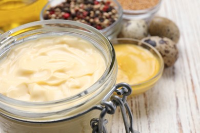 Photo of Delicious homemade mayonnaise, spices and ingredients on white wooden table, closeup