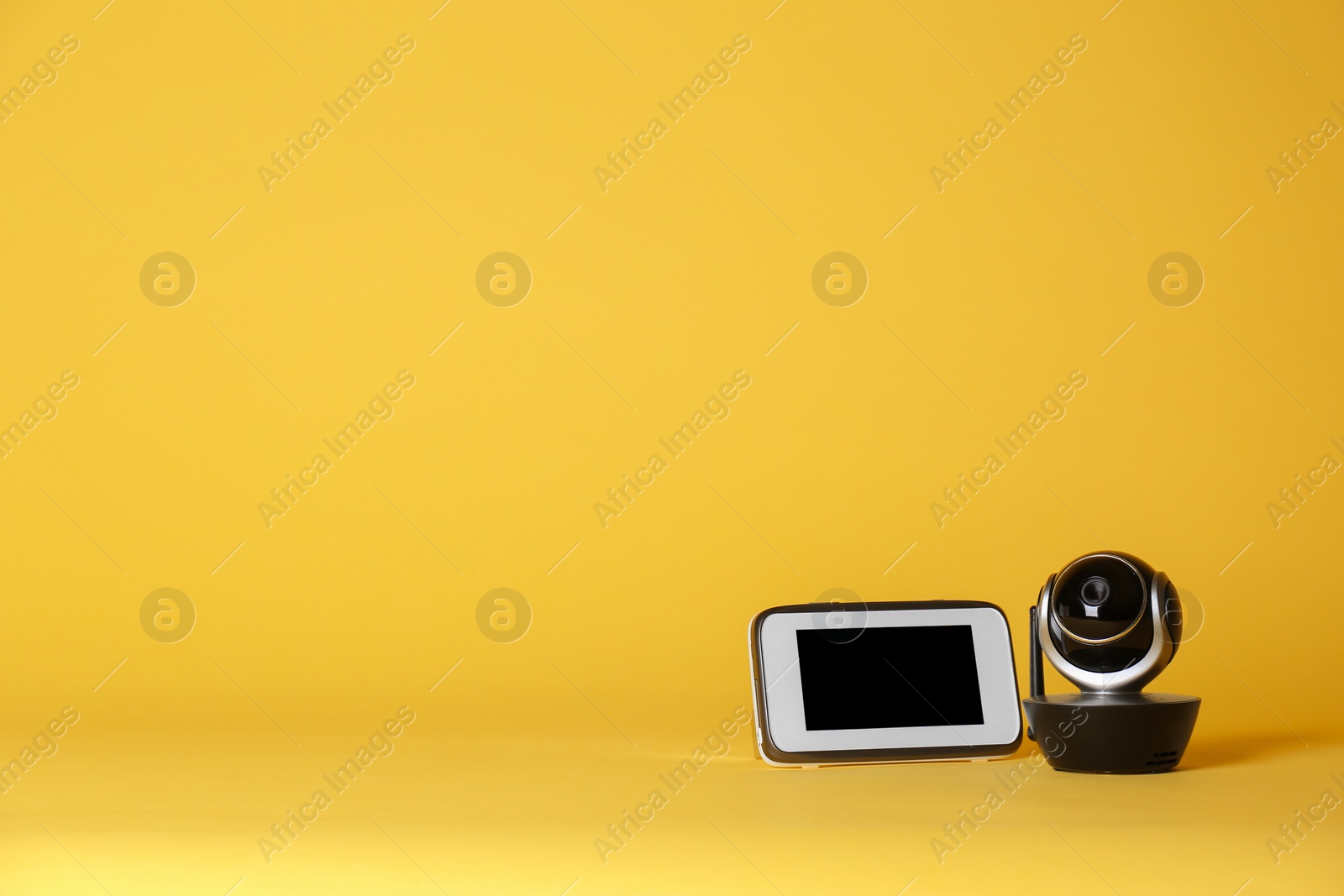 Photo of Modern CCTV security camera and monitor on color background. Space for text