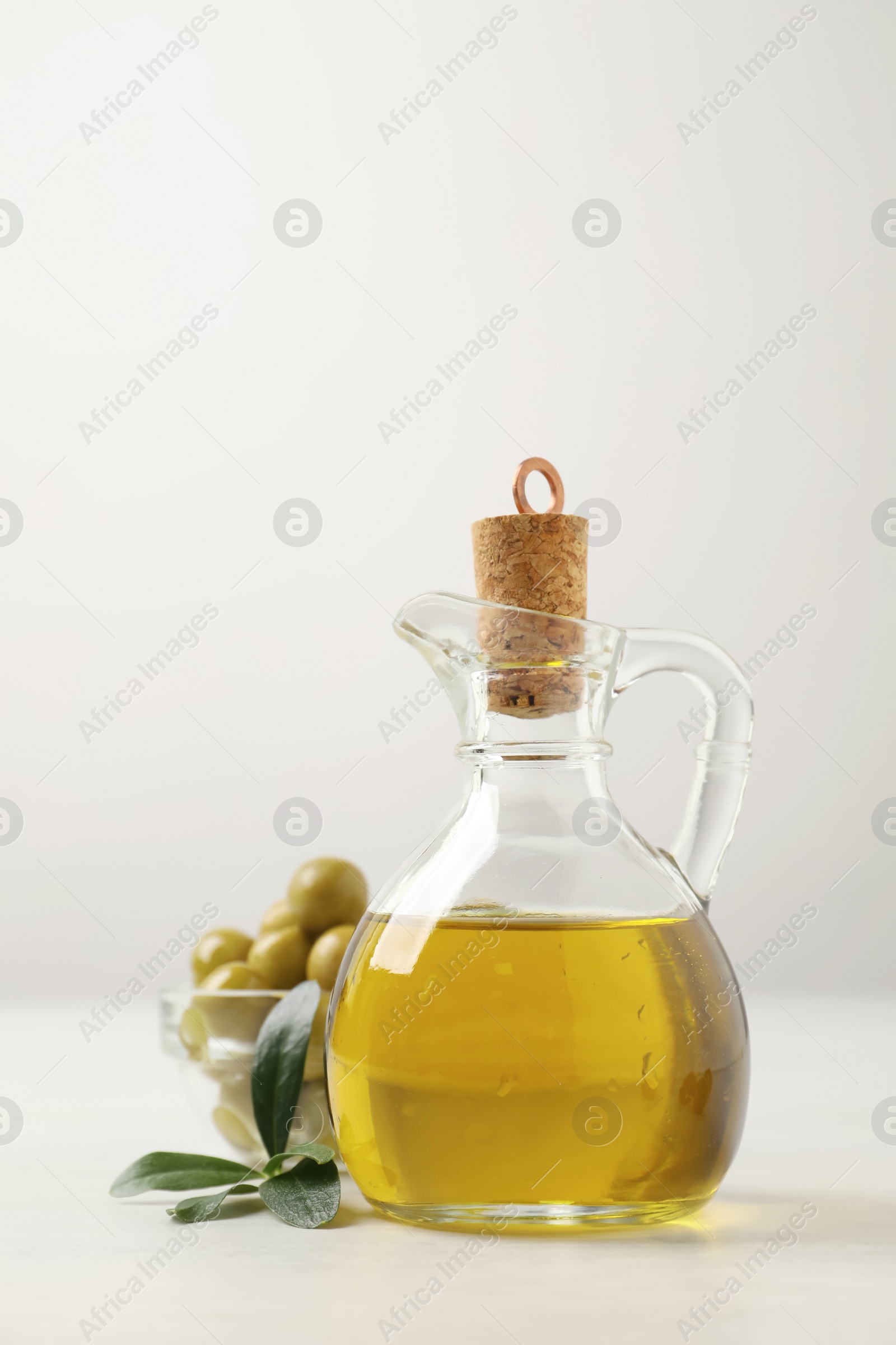 Photo of Bottle of fresh olive oil on white table