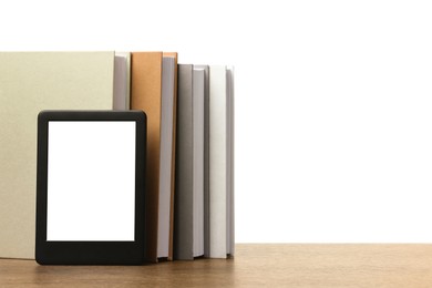 Photo of Hardcover books and modern e-book on wooden table against white background. Space for text