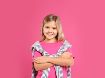 Cute little girl posing on pink background