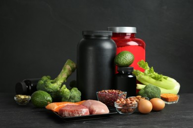 Photo of Set of products rich in amino acids and supplements on black table