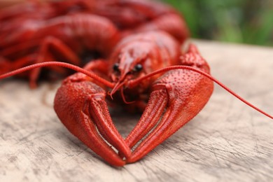 Delicious red boiled crayfish on wooden table, closeup