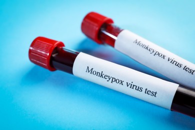 Monkeypox virus test. Sample tubes with blood on light blue background, closeup
