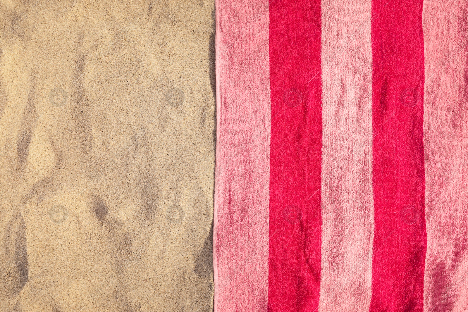 Photo of Soft pink beach towel on sand, top view. Space for text