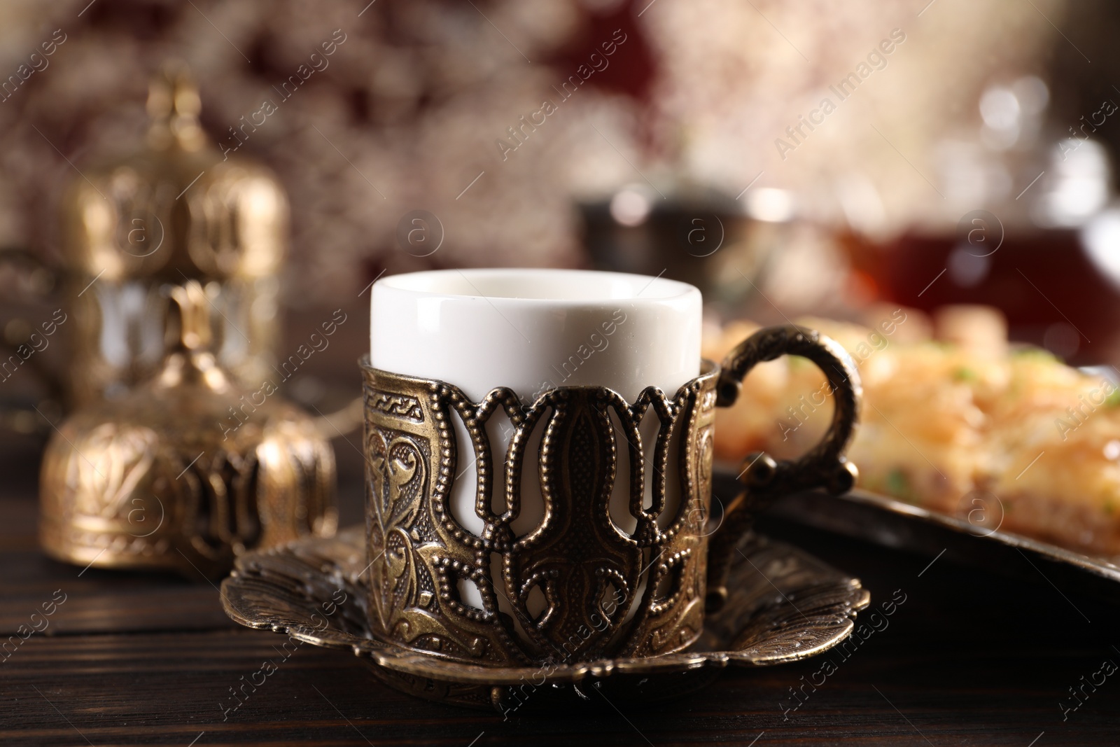 Photo of Traditional Turkish tea served in vintage tea set on wooden table, closeup