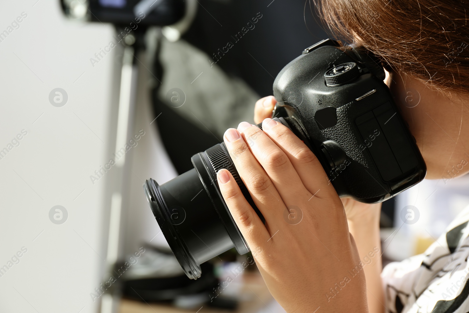 Photo of Female photographer with professional camera on blurred background