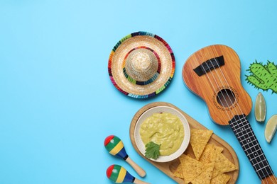 Flat lay composition with Mexican sombrero hat on light blue background, space for text
