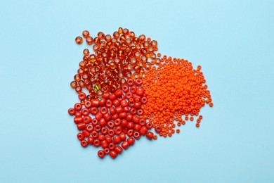 Photo of Pile of different beads on light blue background, flat lay