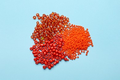 Pile of different beads on light blue background, flat lay