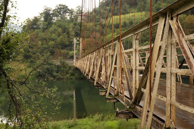 Beautiful view on rusty metal bridge over river in mountains