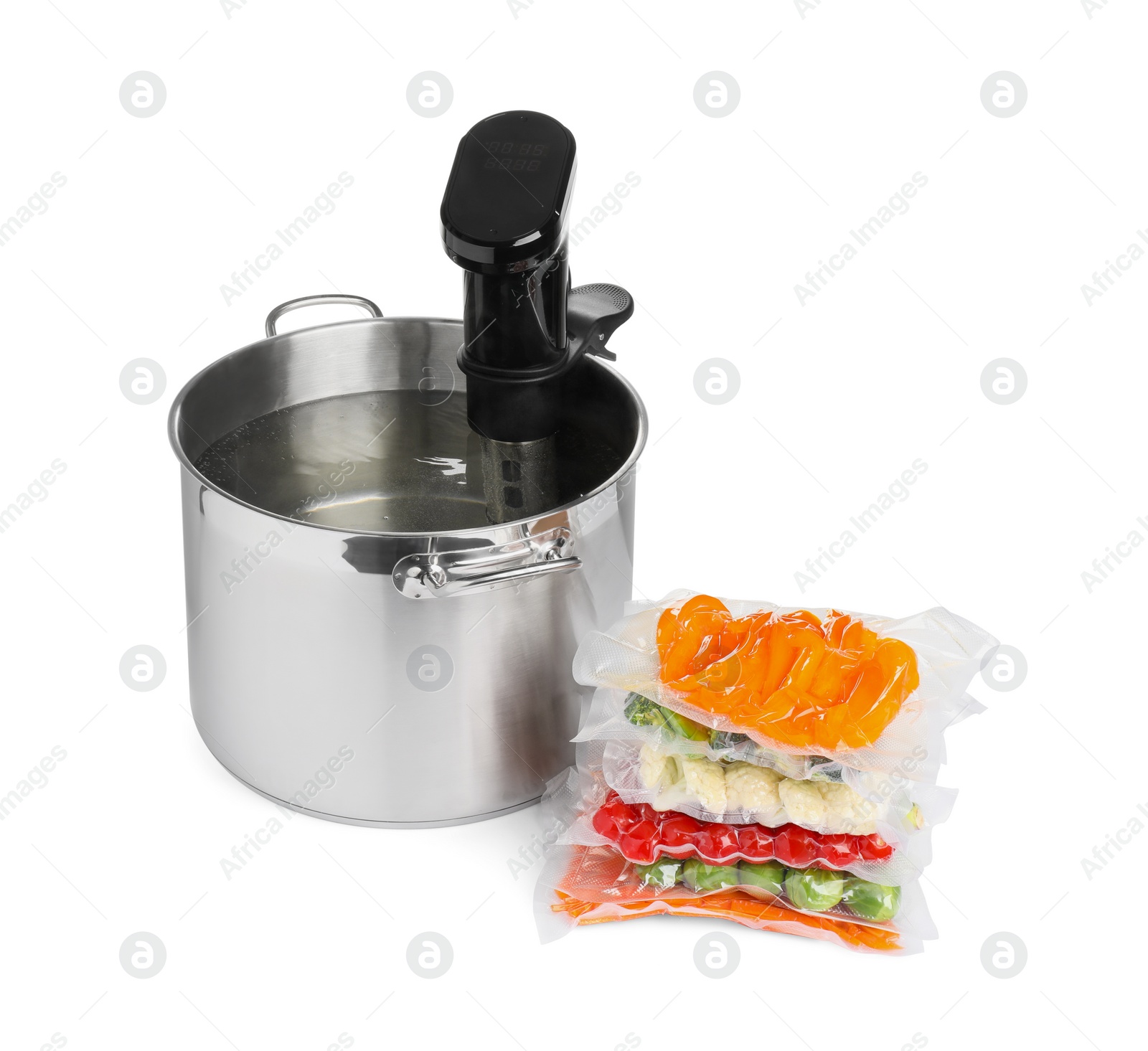 Photo of Thermal immersion circulator in pot and vacuum packs with different food products on white background. Sous vide cooking