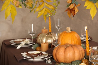 Beautiful autumn place setting and decor on table in room