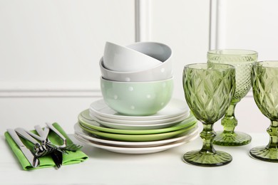Photo of Beautiful ceramic dishware, glasses and cutlery on white table