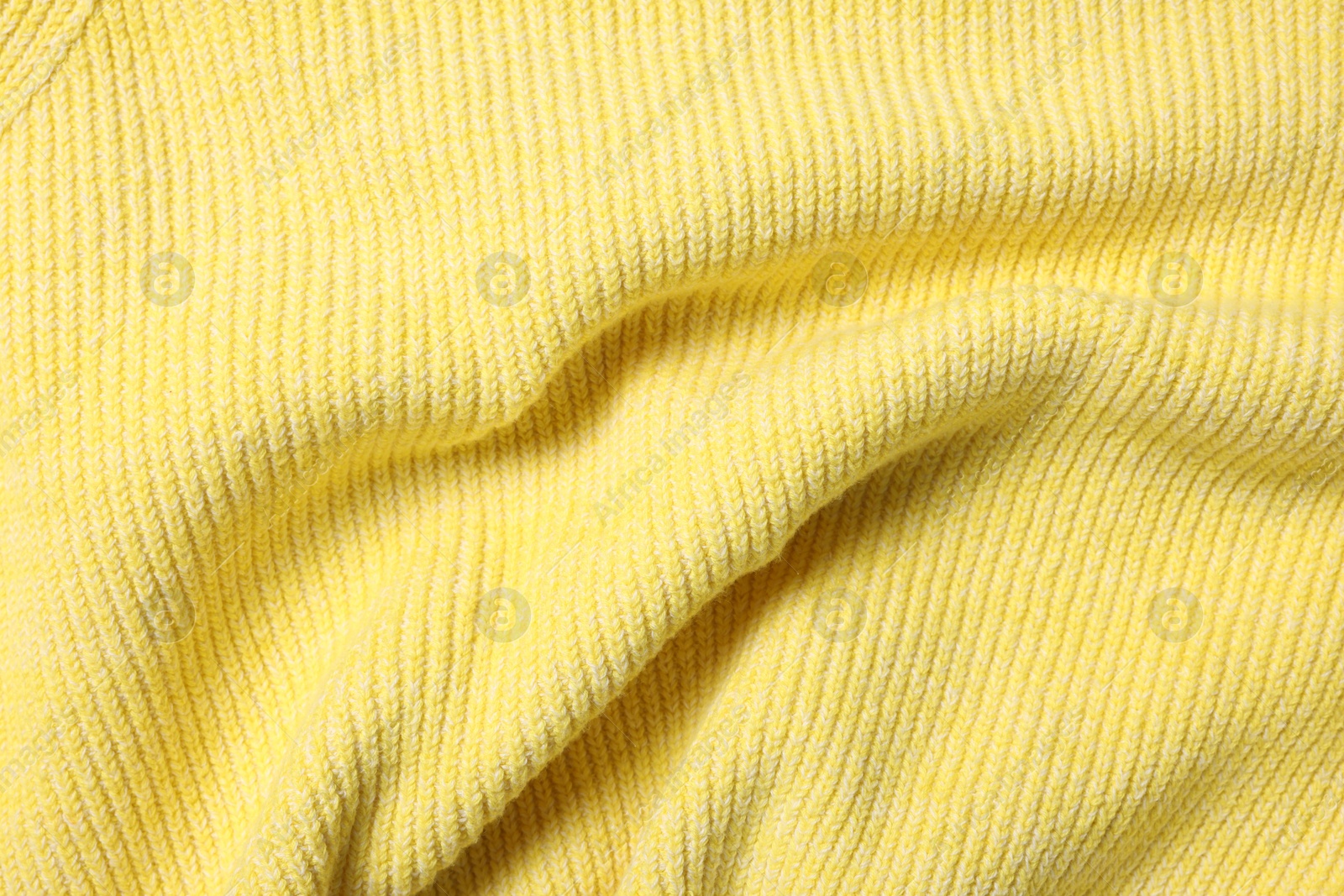 Photo of Texture of soft yellow fabric as background, top view