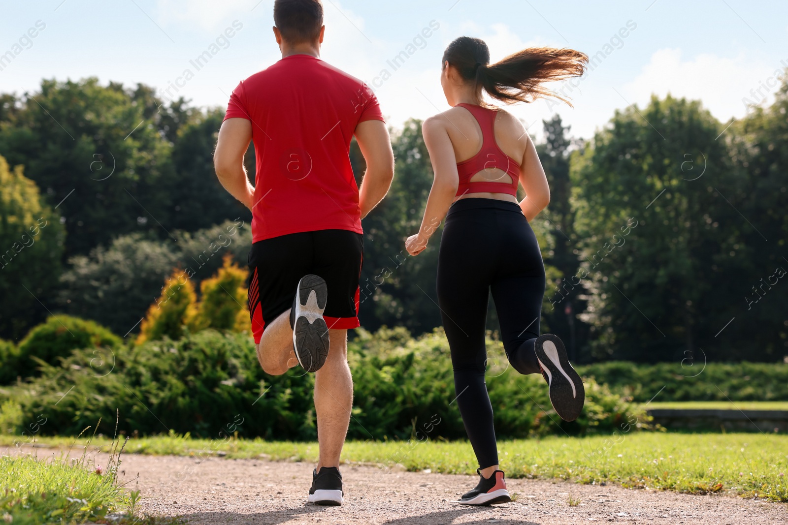 Photo of Healthy lifestyle. Couple running outdoors on sunny day, low angle view