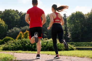 Healthy lifestyle. Couple running outdoors on sunny day, low angle view