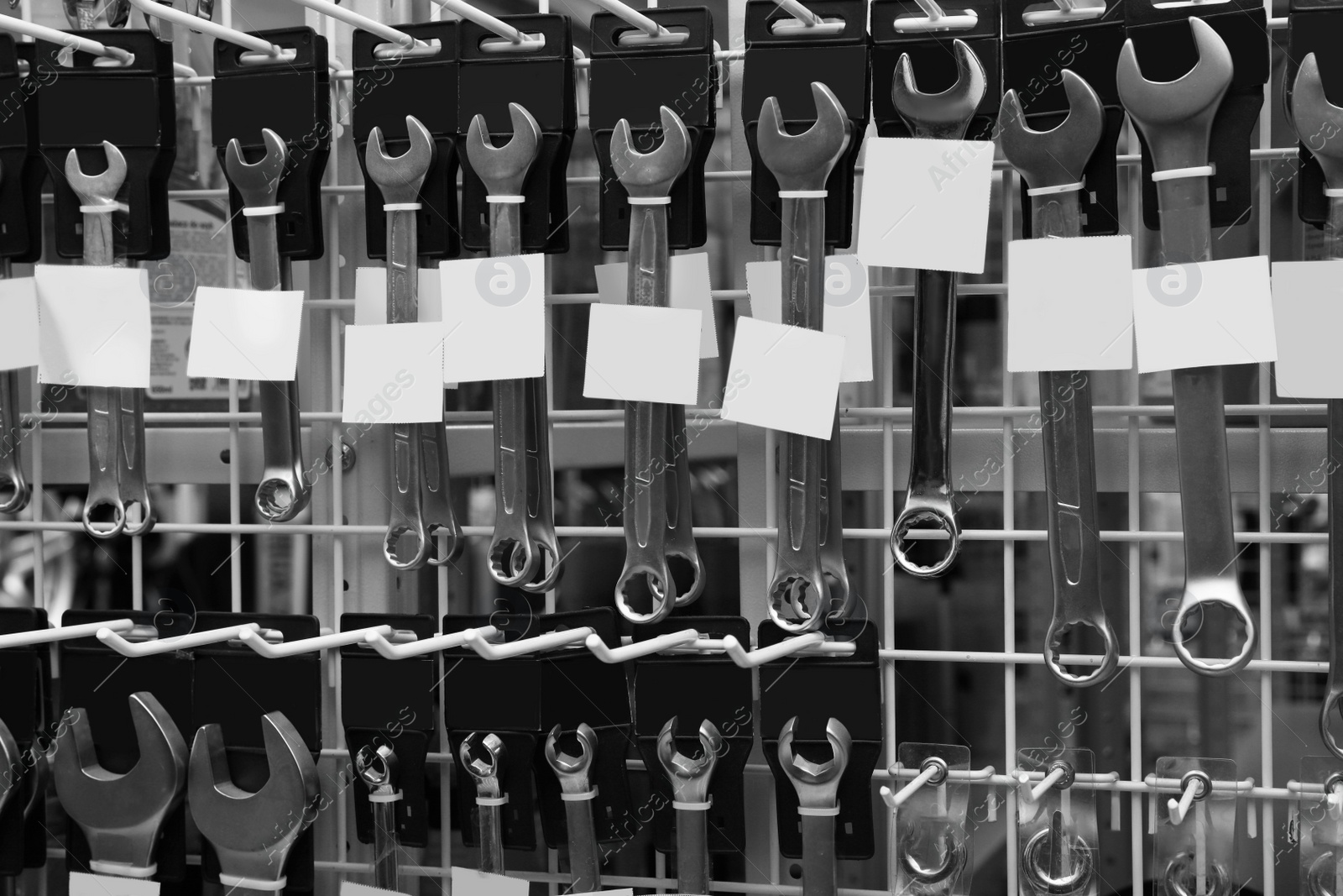 Image of Different wrenches with blank stickers in auto store. Black and white effect