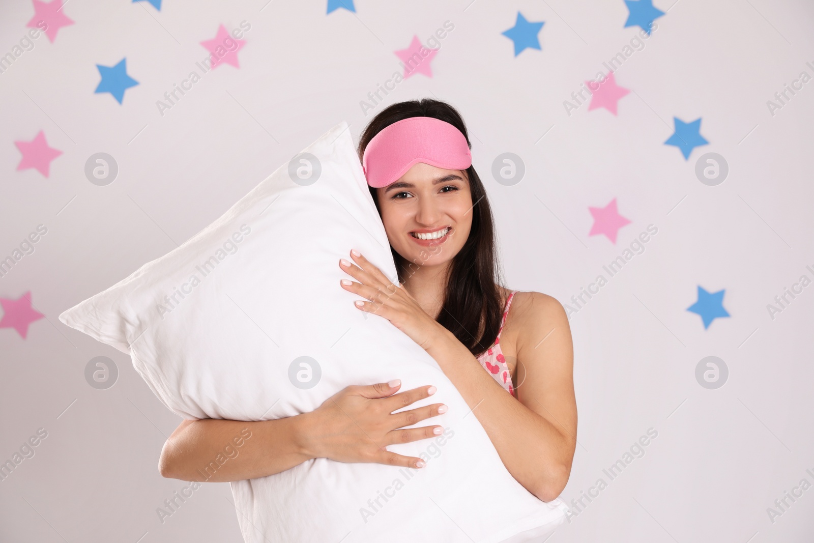 Photo of Beautiful woman with pillow on light grey background. Bedtime