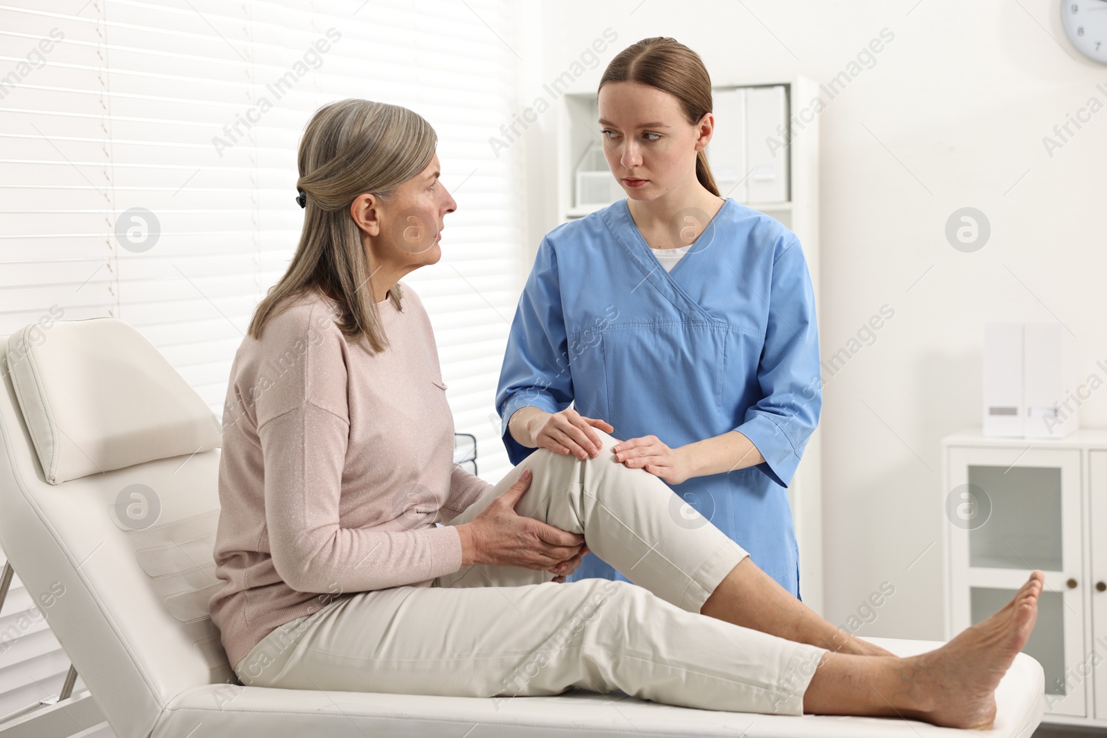 Photo of Arthritis symptoms. Doctor examining patient with knee pain in hospital