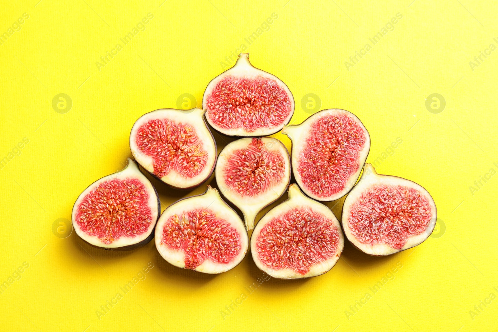 Photo of Cut ripe figs on color background, top view