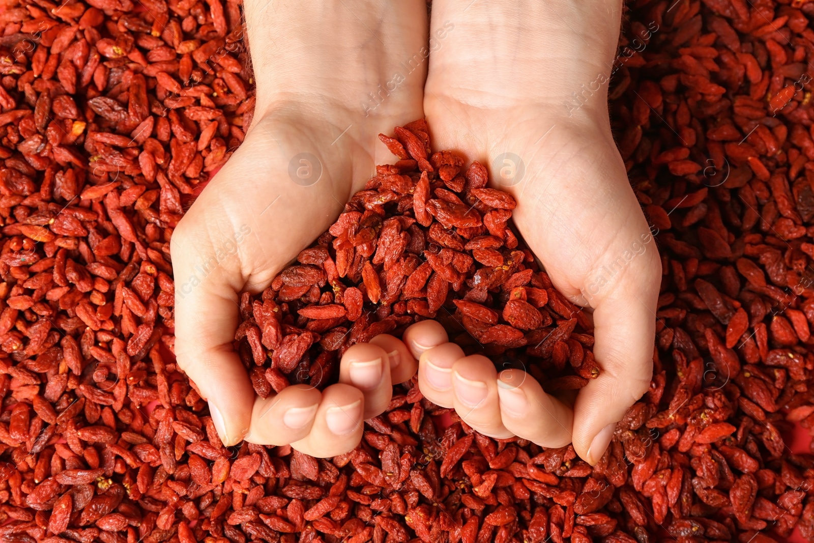 Photo of Woman holding red dried goji berries, top view. Heart health