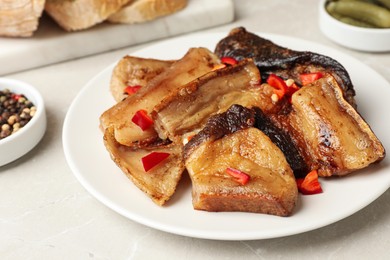 Tasty fried pork lard with pepper on light table