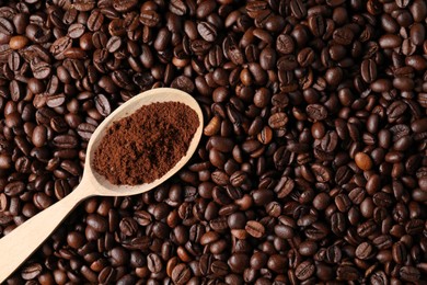 Photo of Spoon with ground coffee on roasted beans, top view. Space for text