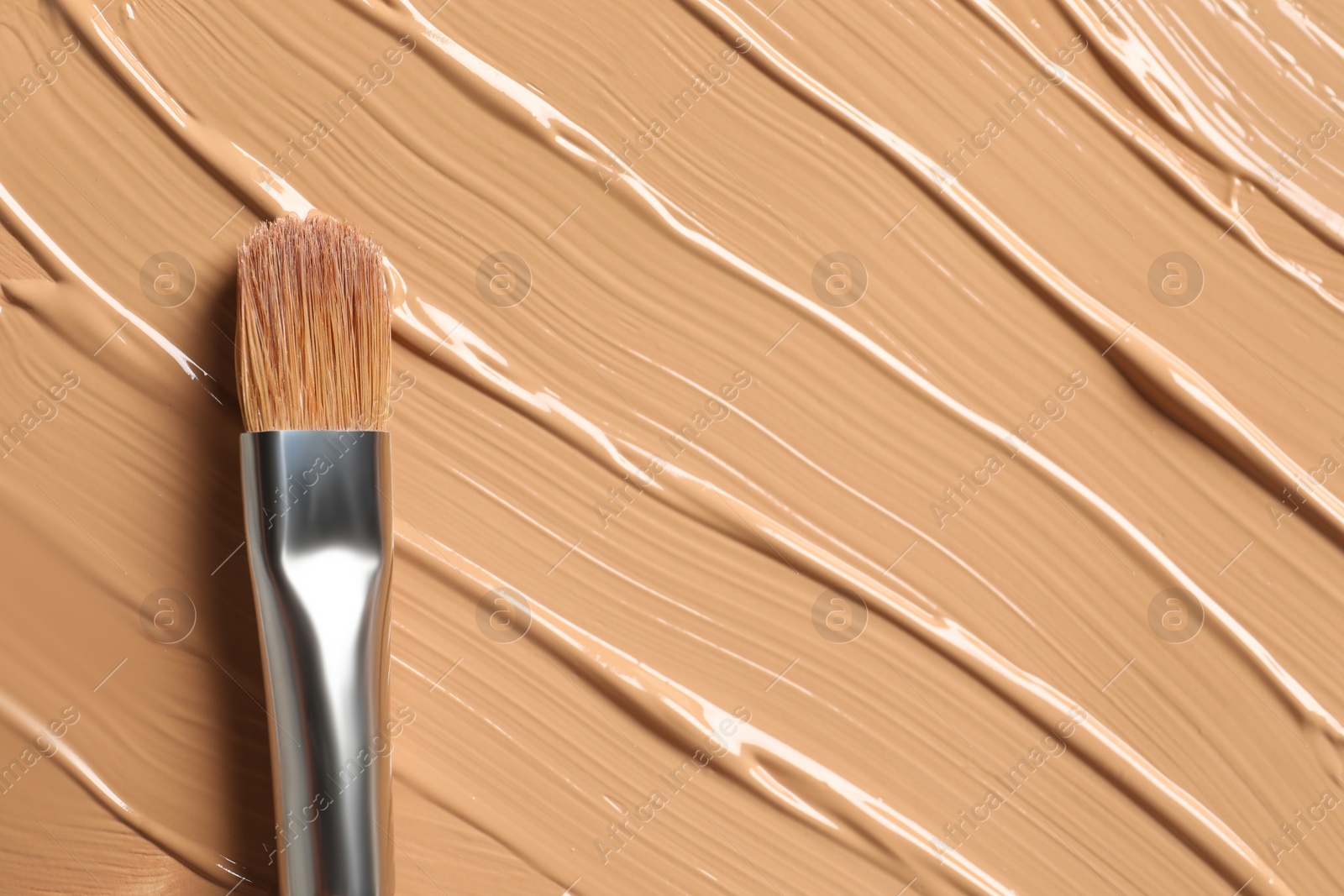 Photo of Skin foundation and makeup brush as background, closeup