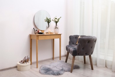 Photo of Stylish room interior with wooden dressing table and armchair