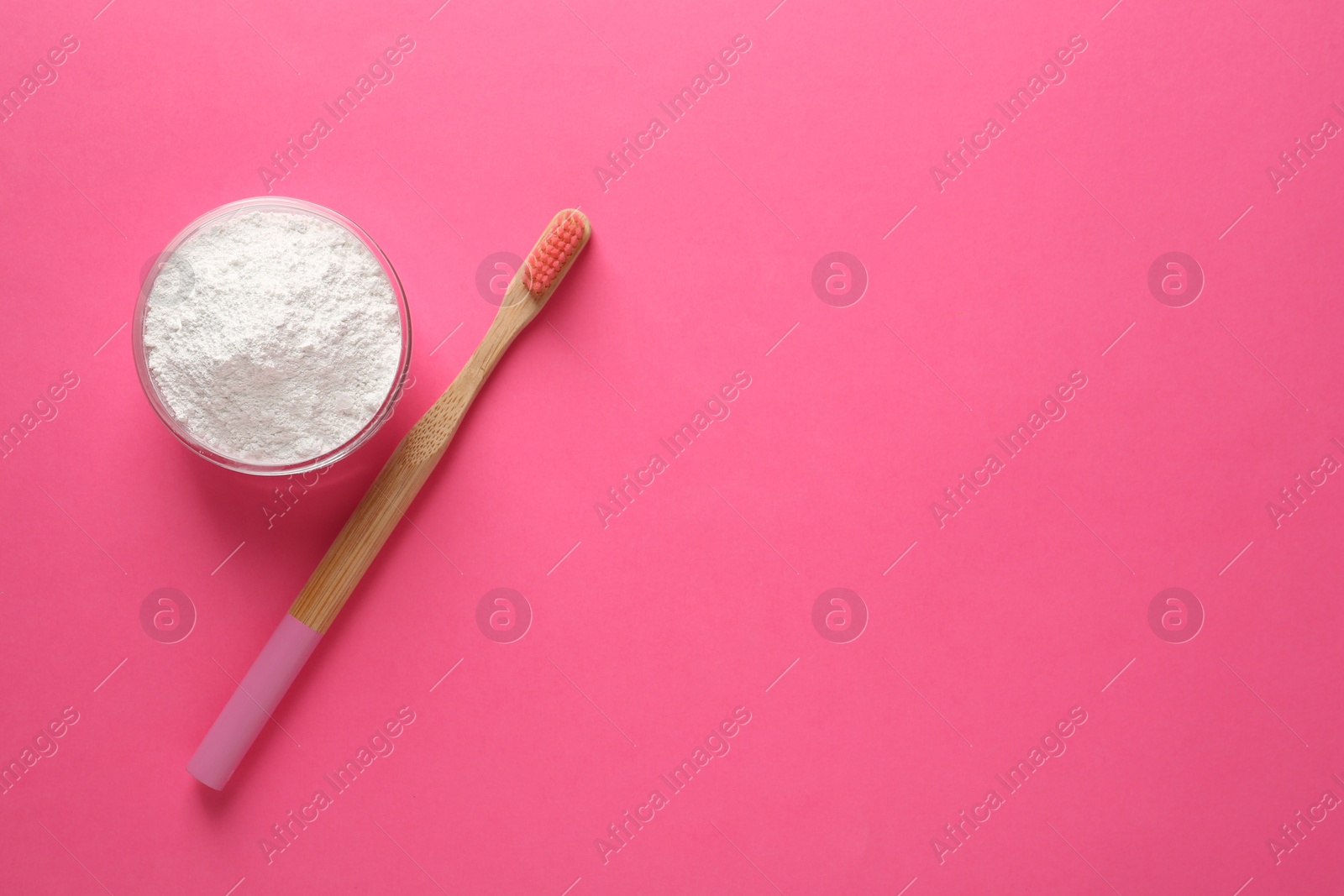 Photo of Bowl of tooth powder and brush on pink background, flat lay. Space for text