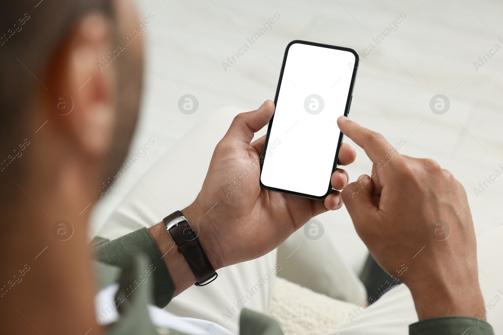 Photo of Man using modern mobile phone indoors, closeup