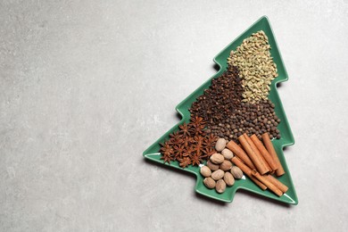 Different spices and nuts on light gray textured table, top view. Space for text
