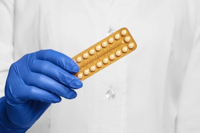 Photo of Doctor holding blister of oral contraception pills, closeup