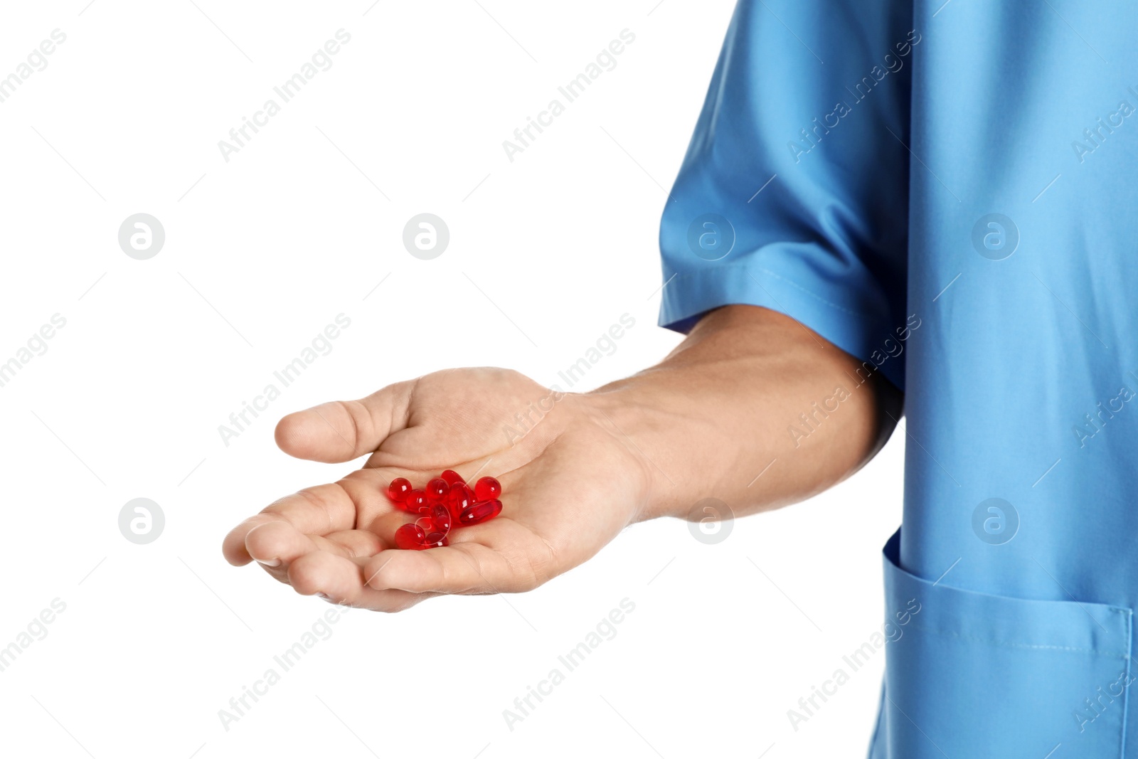 Photo of Male doctor holding pills on white background, closeup. Medical object