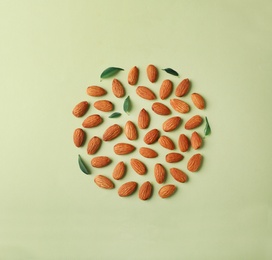 Composition with organic almond nuts on color background, top view