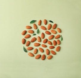 Photo of Composition with organic almond nuts on color background, top view