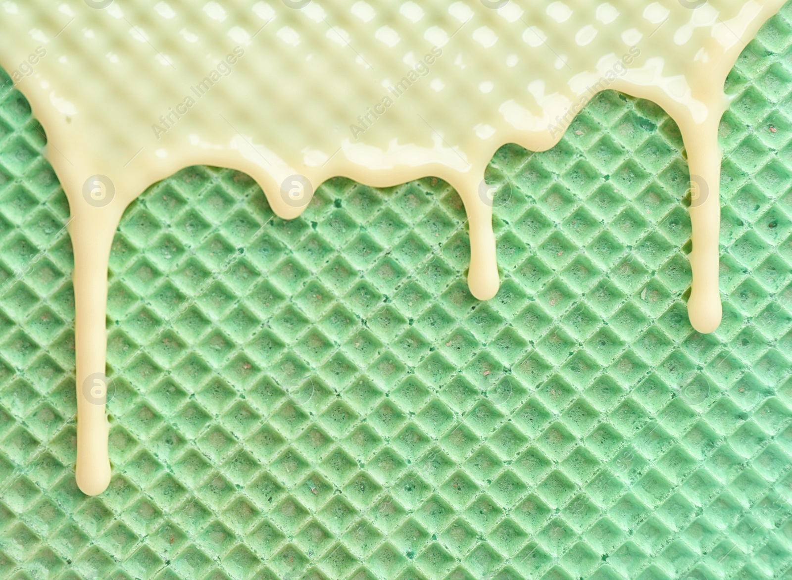 Photo of Hot white chocolate on wafer, closeup. Crispy food