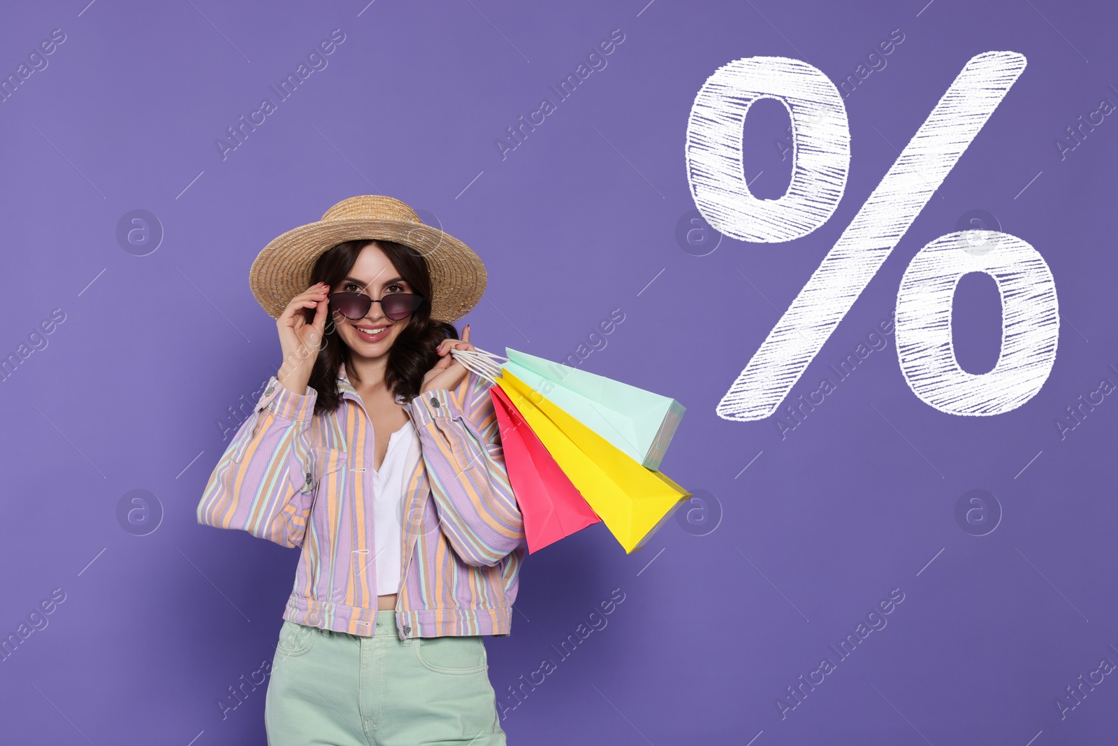 Image of Discount offer. Happy woman with paper shopping bags and chalked percent sign on purple background