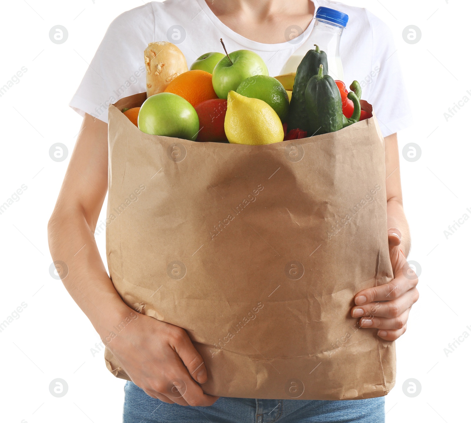 Photo of Woman holding paper bag with different groceries on white background, closeup view