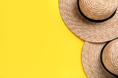 Photo of Stylish straw hats on yellow background, flat lay. Space for text
