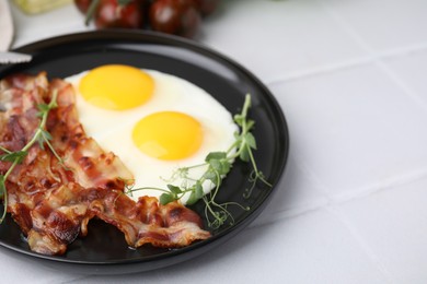 Fried eggs, bacon and microgreens on white tiled table, closeup. Space for text