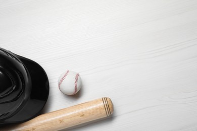 Sports equipment. Helmet, ball and baseball bat on white wooden table, flat lay. Space for text